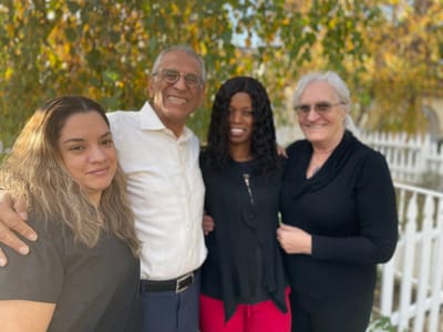 Staff and residents smiling together outdoors
