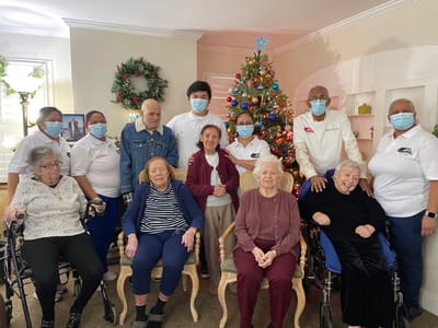 Residents and staff gathered around a Christmas tree