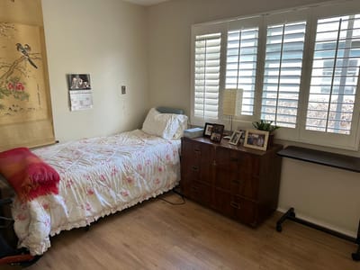 Cozy resident room featuring a bed and storage dresser