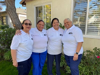 Staff members smiling outside in front of the facility