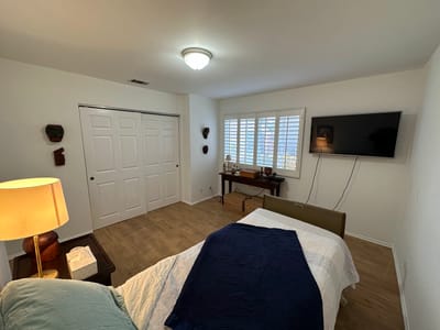 Brightly lit private resident room with a bed and furniture