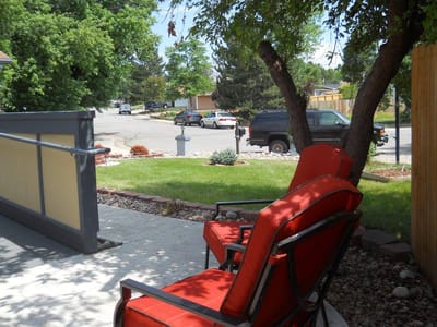 Outdoor seating area with red chairs and green lawn