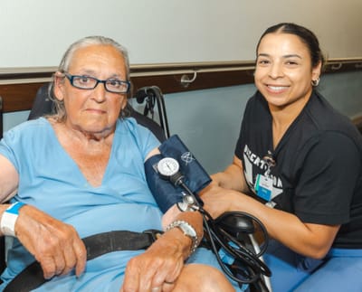 Staff member taking a resident's blood pressure