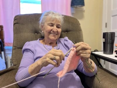 Resident knitting in a cozy chair