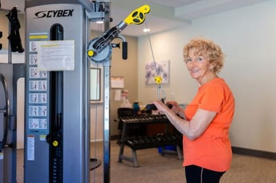 A resident exercising in the fitness area of the facility