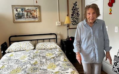 Resident standing in her furnished room.