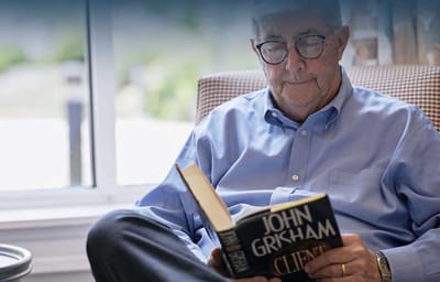 Resident reading a book in a cozy setting