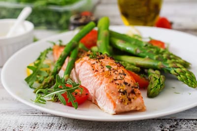 Plate of salmon with asparagus and tomatoes
