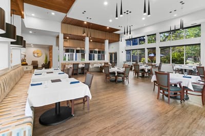 Bright dining room with tables set for residents