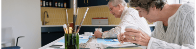 Two residents engaging in a creative activity indoors