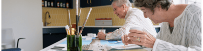 Residents engaged in an art activity at a communal table