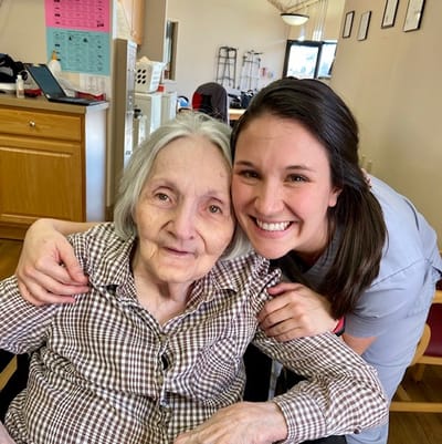 Resident and staff member smiling together