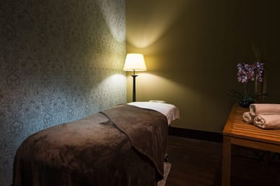 Serene spa room with massage table and lamp