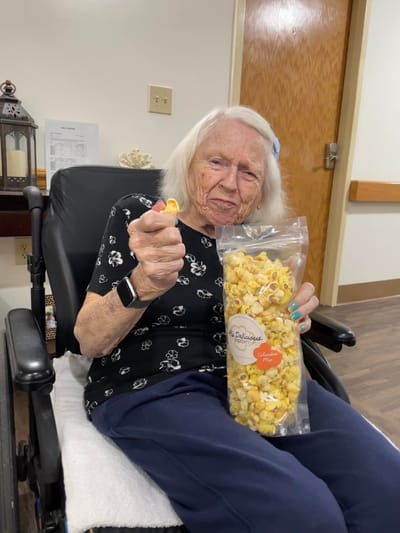 Elderly resident enjoying popcorn in a cozy setting