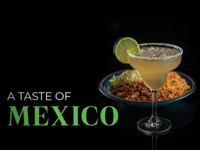 A margarita and Mexican food on a dark background
