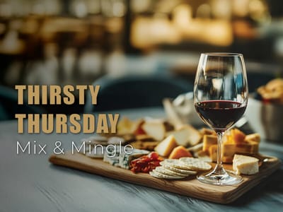 A glass of wine and cheese platter on a table