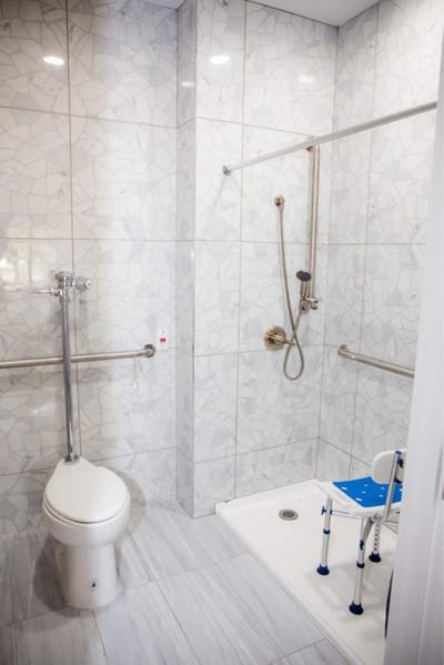 Accessible bathroom with grab bars and shower chair