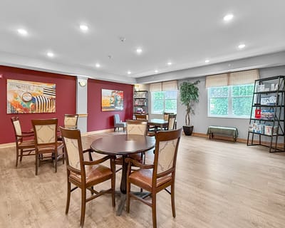 Common area with tables and chairs in a senior living facility