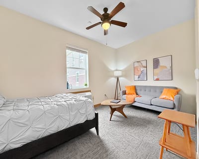 A cozy resident room with a bed and seating area