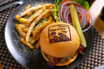 A burger and fries with the Essex Meadows logo
