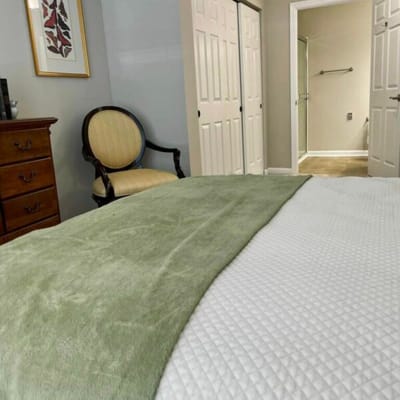 Interior view of a resident's room with a bed and chair