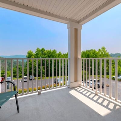 Balcony view with green trees and parking lot