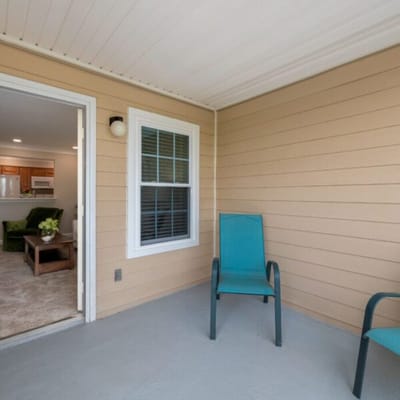 Seating area on a porch with green chairs