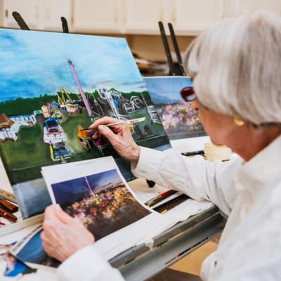 Resident painting in a vibrant activity room