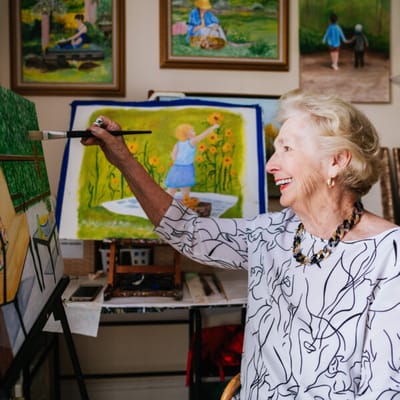 A resident painting in an activity room