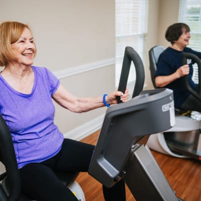 Residents using exercise equipment in an activity room