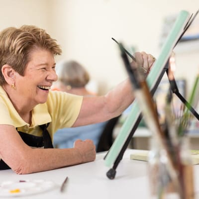 Resident enjoying a painting activity in a creative space
