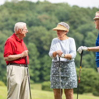 Three seniors enjoying a sunny day on the golf course