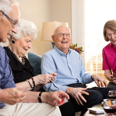 Residents enjoying a card game in a cozy seating area