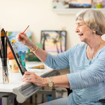 Senior resident painting in an activity room