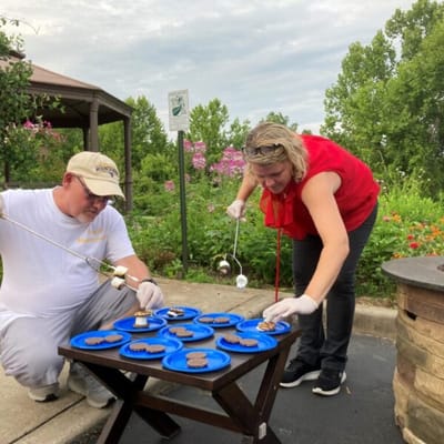 Residents making s'mores in a garden area