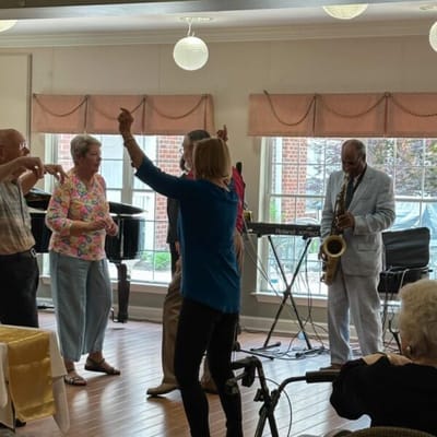 Residents dancing with live music in a common area
