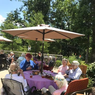 Residents enjoying lunch outdoors under umbrellas