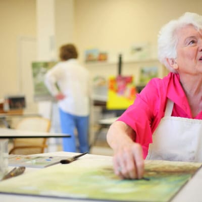 Resident painting in an art activity room