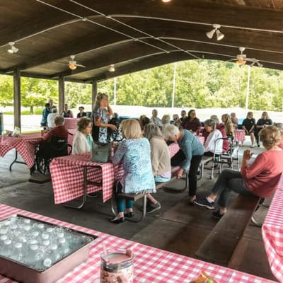 Residents gathered for an outdoor event under a pavilion