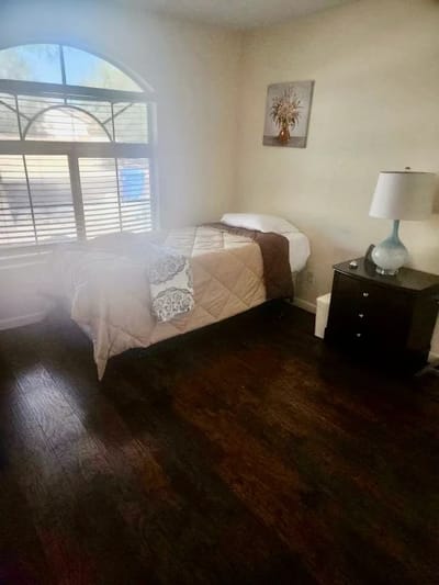 Interior view of a resident room with bed and lamp