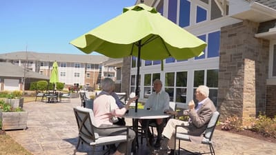 Residents enjoying time outdoors under an umbrella