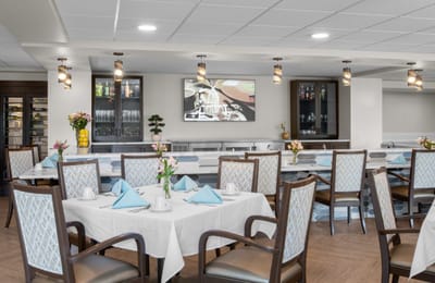 Dining room with neatly set tables and a TV