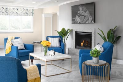Bright common area with blue chairs and a fireplace