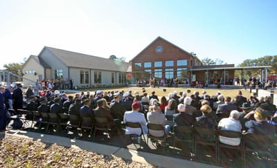 Outdoor ceremony with a crowd in front of the facility