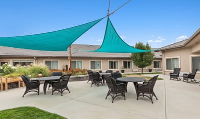 Outdoor seating area with shade sails and tables