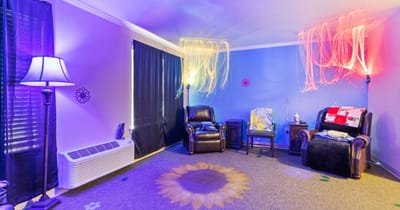 A sensory room with calming lighting and chairs