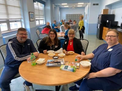 Residents and staff enjoying a meal together in the dining area