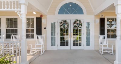 Welcoming entrance with rocking chairs and floral wreaths