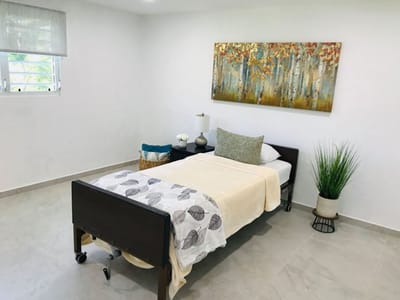 A well-decorated resident room with a bed and artwork