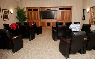 A cozy common area with reclining chairs and a TV
